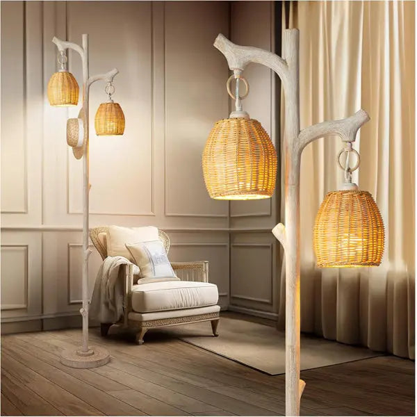 A cozy room with a cushioned armchair and the Scenekoy 68 High Farmhouse Rustic Country Cottage Floor Lamp, a tree trunk faux wood design with three wicker drum shades, stands out against paneled walls and wooden flooring.